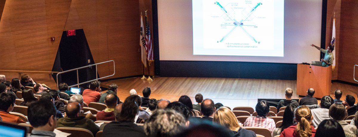 Audience watching a lecture held at the neighboring Merck Auditorium during the Optical Microscopy Symposium in 2016 in celebration of the 15th anniversary of the Nikon Imaging Center at HMS.
